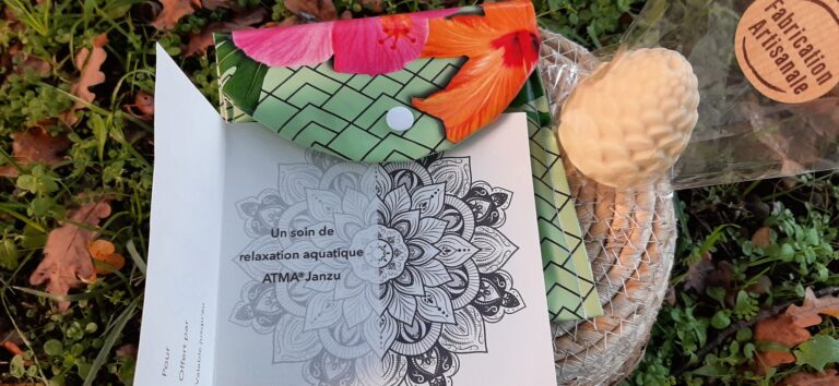 Pochette cadeau verte avec des fleurs avec un bon pour une séance de relaxation aquatique et un savon